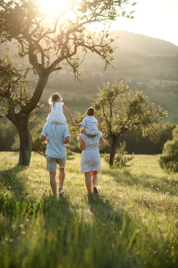A family walking through a sunlit field